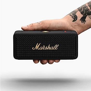 Hand holding a black Marshall Emberton II portable Bluetooth speaker.