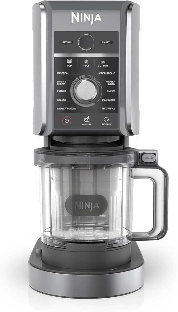 Front view of the Ninja Creami Deluxe 11-in-1 frozen dessert maker in gray and silver, showing control panel and clear pint container.