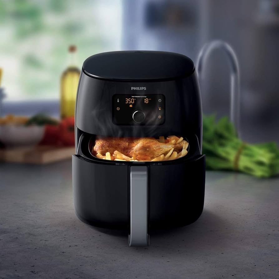 Black Philips Premium Airfryer XXL cooking a whole chicken and fries. Digital display shows 350 degrees and 18 minutes.
