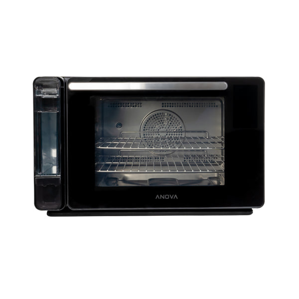 Front view of black Anova Precision Oven, featuring a transparent water tank, glass door, and stainless steel interior with racks.