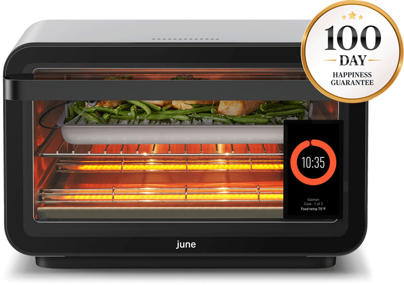 June smart oven cooking salmon and green beans with glowing elements, digital display showing time, cooking mode, and food temp.